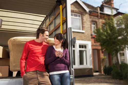 Professional movers carrying household items in a central London property